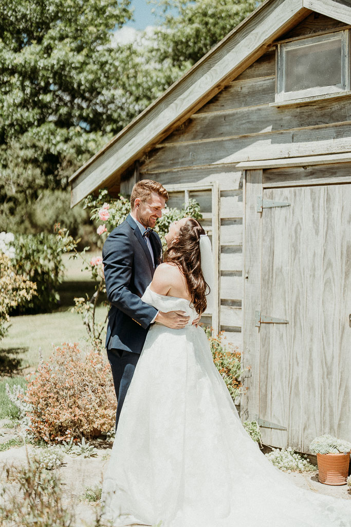 Bride and groom sharing a joyful embrace in front of a rustic wooden shed, perfectly orchestrated by an On the Day Wedding Coordinator Perth.